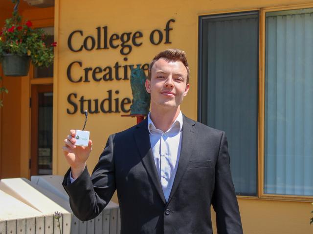 Alex Cicconi-Kasper holds the prototype for his recyclable, single-use cellphone charger he designed for +Charge